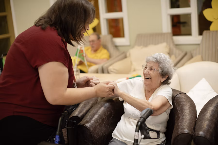 Physiotherapist assisting a senior patient at home